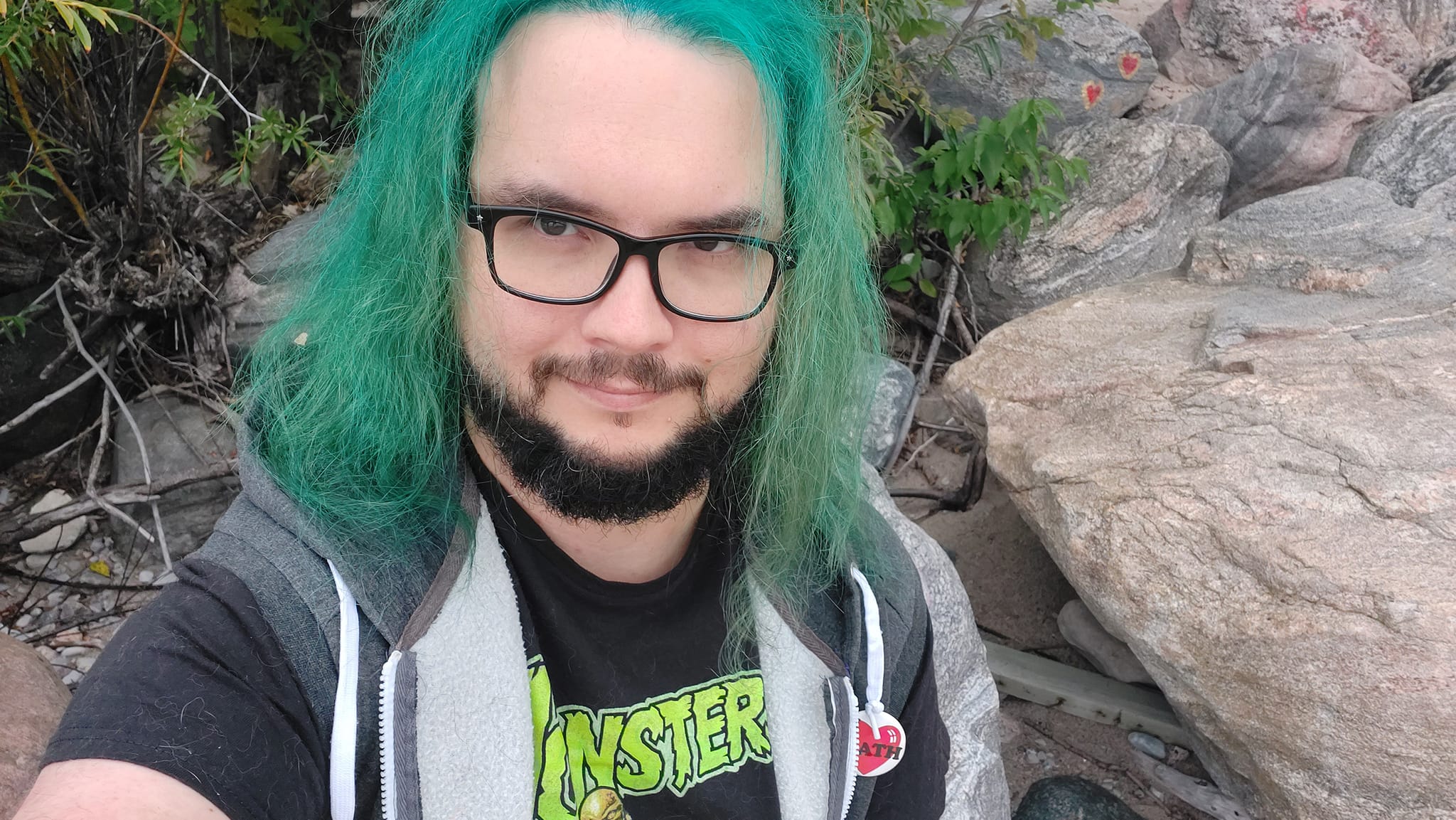 A man with green hair stands outside at a boulder breakwater, photo 9